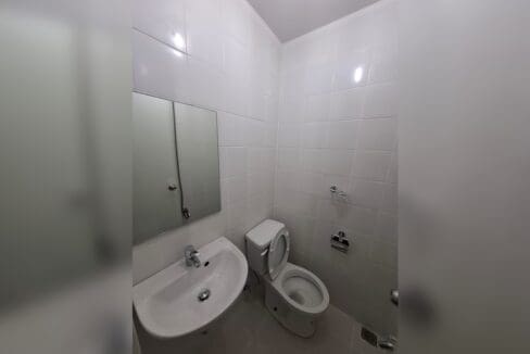 Bathroom with a wall-hung basin, mirror and toilet.