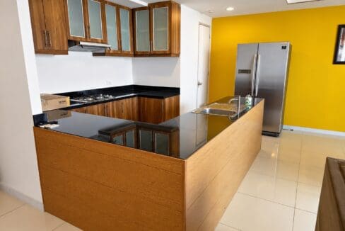 U-shaped kitchen with a gas hob, stainless range hood and a granite-topped peninsula with a double sink