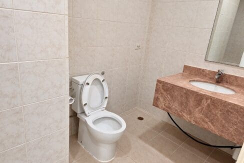 Bathroom finished in beige tile with a marble vanity and undermount basin at Marco Polo Residences