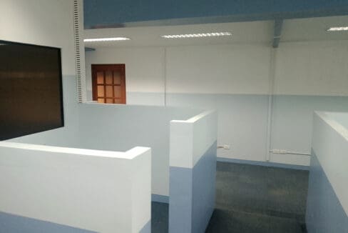 Cubicle workstations facing the wall-mounted screen in the staff area