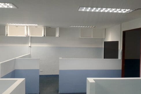 Cubicle workstations with overhead storage cabinets along the wall