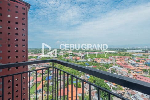 Balcony view across Lapu-Lapu City rooftops toward the Cebu mainland skyline