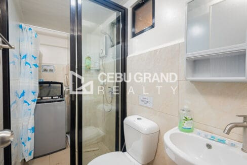 Bathroom with a glass shower enclosure, instant water heater, washing machine and wall-hung basin