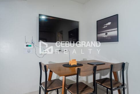 Dining corner with a four-seater table under the wall-mounted television