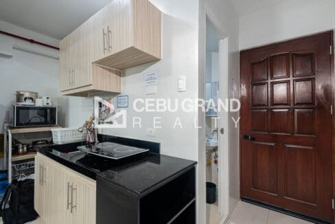 Kitchen run in black granite with an induction cooker, next to the timber entry door
