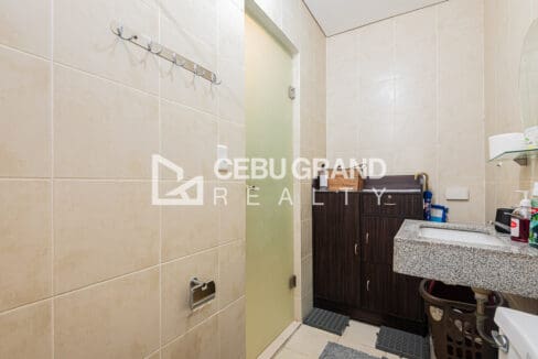 Bathroom storage cabinet beside the frosted-glass door