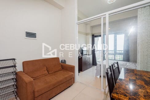 Sofa in the living area beside the glass sliding doors to the bedroom