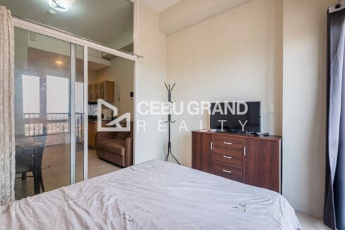 View from the bed toward the dresser, TV and the living area beyond the glass doors