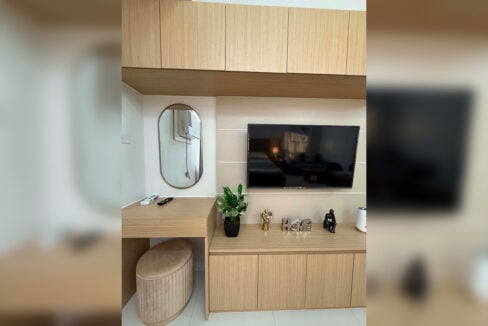 TV wall with a vanity desk and oval mirror