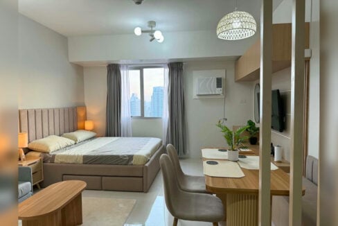 Furnished studio with city view for rent at Taft East Gate, with the bed, dining nook and window