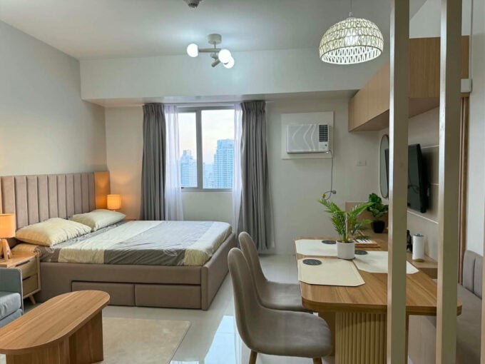 Furnished studio with city view for rent at Taft East Gate, with the bed, dining nook and window