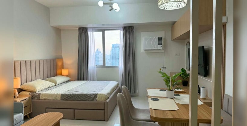 Furnished studio with city view for rent at Taft East Gate, with the bed, dining nook and window