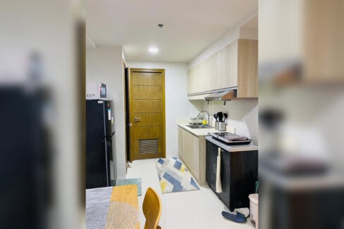 Kitchen with wood-grain cabinets, range hood, induction cooktop and refrigerator