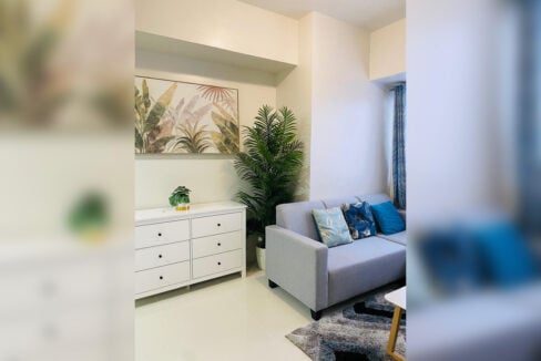 White dresser, artwork and sofa in the living area
