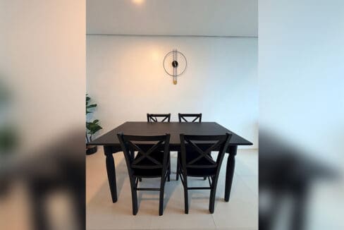 Black dining table with cross-back chairs and a spoke wall clock in the 2BR condo for rent at 38 Park Avenue, Cebu IT Park
