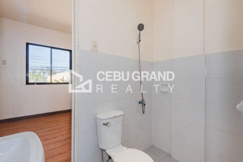 Upstairs toilet and bath, tiled with a shower and a window to the street