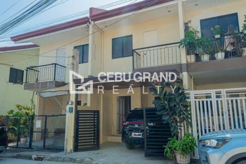 Street frontage of the two-storey attached townhouses at Adamah Homes North, each with a balcony above its carport