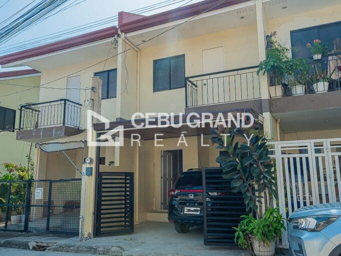 Street frontage of the two-storey attached townhouses at Adamah Homes North, each with a balcony above its carport