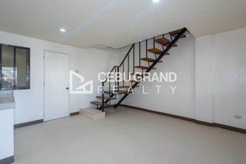 Ground floor living area with the open-riser timber stair and the kitchen counter to the left