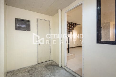 Covered service area outside the ground-floor entry, with the door to the toilet and bath