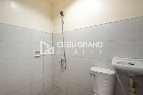 Ground floor toilet and bath, fully tiled with a shower and wall-hung basin