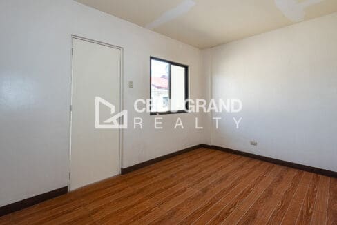 Bedroom with timber-look flooring, a window and a door to the landing