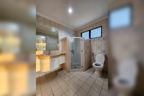 Bathroom with corner glass shower, vanity and louvered window