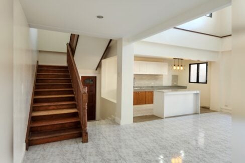 Wooden staircase beside the living area and kitchen