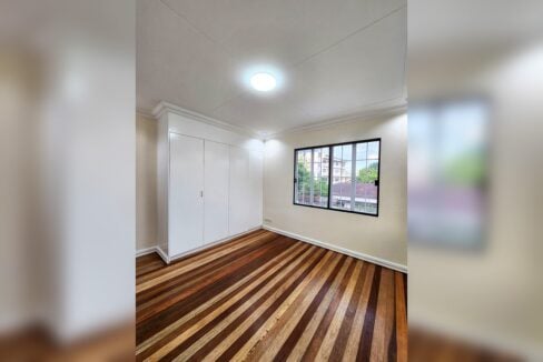 Bedroom with white built-in wardrobe and hardwood floors