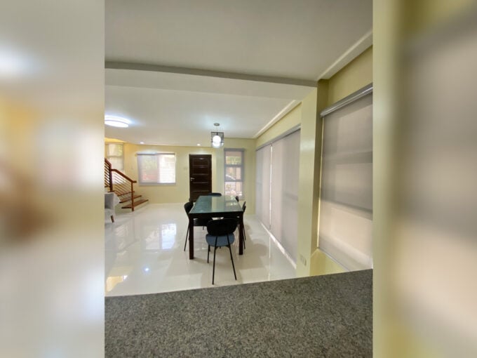 Open living and dining area of the 4 bedroom house for rent in Talamban, with the staircase and front door
