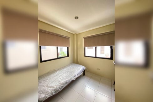 Small bedroom with a single bed and two windows