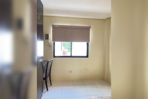 Bedroom with a study desk, wardrobe and window-type air conditioning