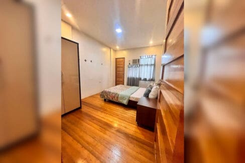 Bedroom with double bed, wardrobe, bedside table and window-type air conditioning