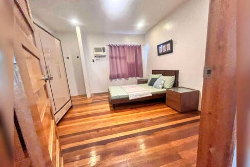 Bedroom with double bed, bedside tables, wardrobe and air conditioning in a Banilad house for rent