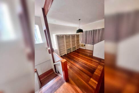 Upstairs family area with built-in bookshelves, pendant light and air conditioning