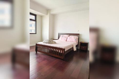 Bedroom with a slatted timber bed, bedside tables and hardwood flooring