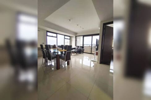 Dining table with six chairs and living area with city-view windows in an Alcoves condo