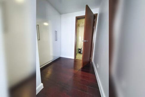 Walk-through wardrobe with white gloss closets leading to the bathroom