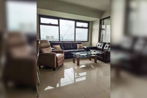 Leather sofas, recliner armchair and glass coffee table with city views