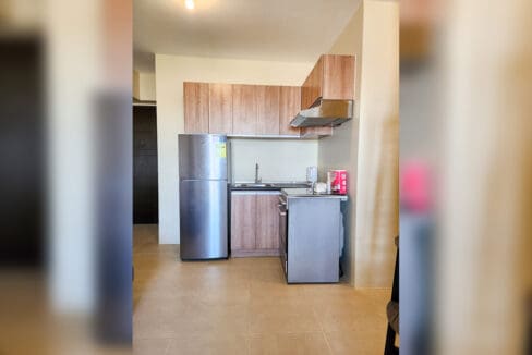 Kitchen with two-door refrigerator, sink and freestanding range in an Avida Riala condo
