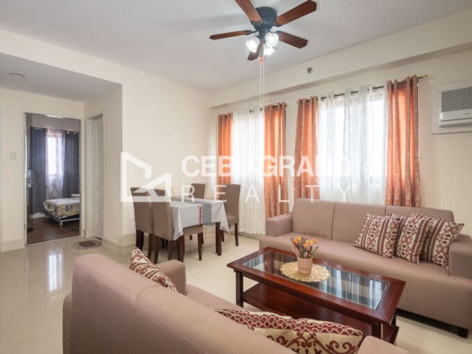 Furnished 2BR condo for sale at Grand Residences, with the living and dining area under a ceiling fan and a view through to the bedroom