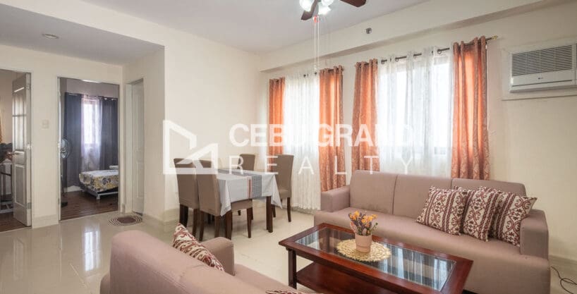 Furnished 2BR condo for sale at Grand Residences, with the living and dining area under a ceiling fan and a view through to the bedroom