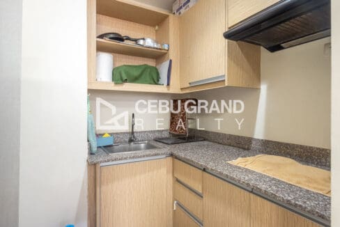 Kitchen with granite counters, light timber cabinets, a stainless sink and a range hood