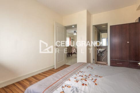 Master bedroom looking toward its ensuite bathroom, with a dark timber wardrobe alongside