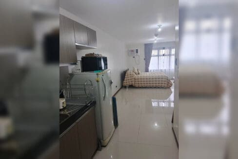 Kitchen and open studio layout of the furnished studio at Galleria Residences, Tower 3, with refrigerator and microwave