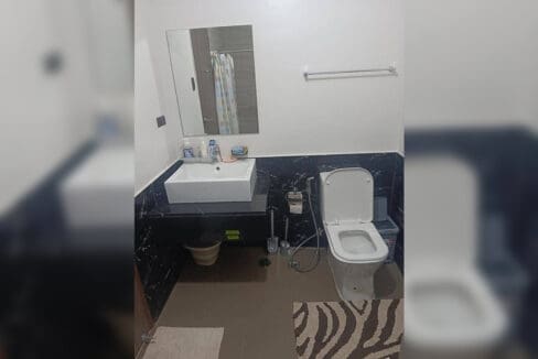 Bathroom with vessel sink on a black stone counter in the furnished studio at Galleria Residences