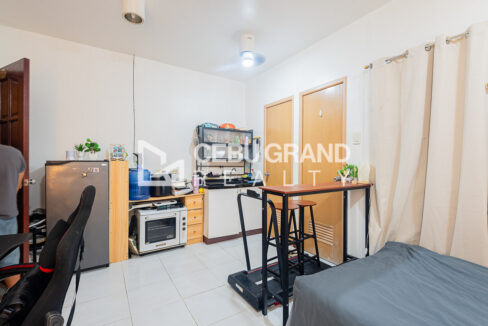 Kitchen counter with a wall shelf, refrigerator, oven and water dispenser in the La Guardia Flats studio