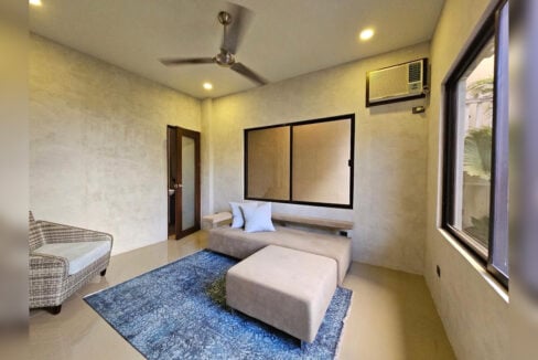 Ground-floor room with a ceiling fan and window-type air conditioning