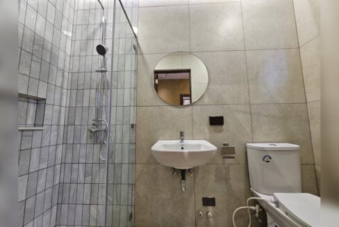 Bathroom with a glass shower enclosure and round mirror