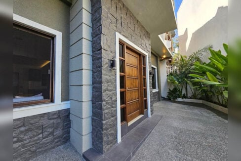Timber front door and stone-clad entry of the house
